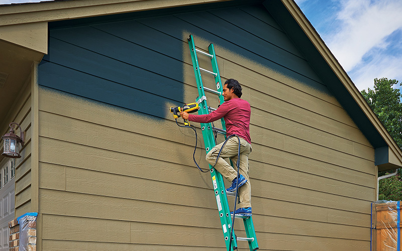 Using a paint sprayer to paint the exterior of a house